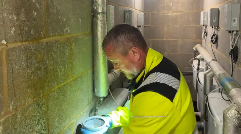 Centra drainage engineer working on washroom pipework by head torch during an out-of-hours visit