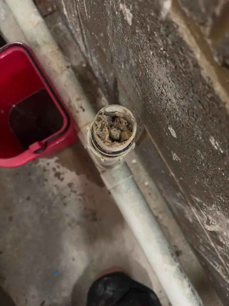 Washroom waste pipe packed with scale and sludge before descaling